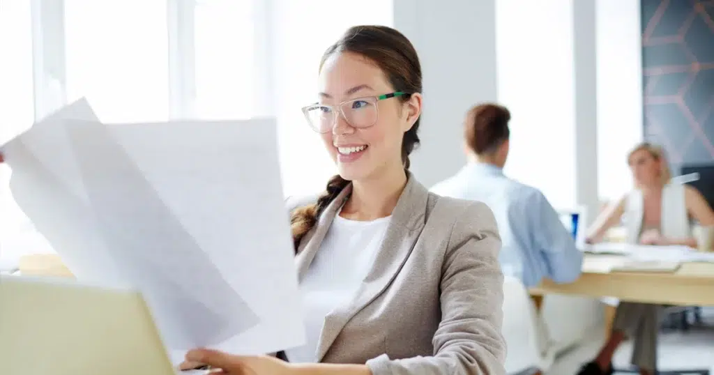 Minijob: flexible Arbeitsmodelle und Arbeitszeiten Frau im Minijob, schaut sich Arbeitsunterlagen an