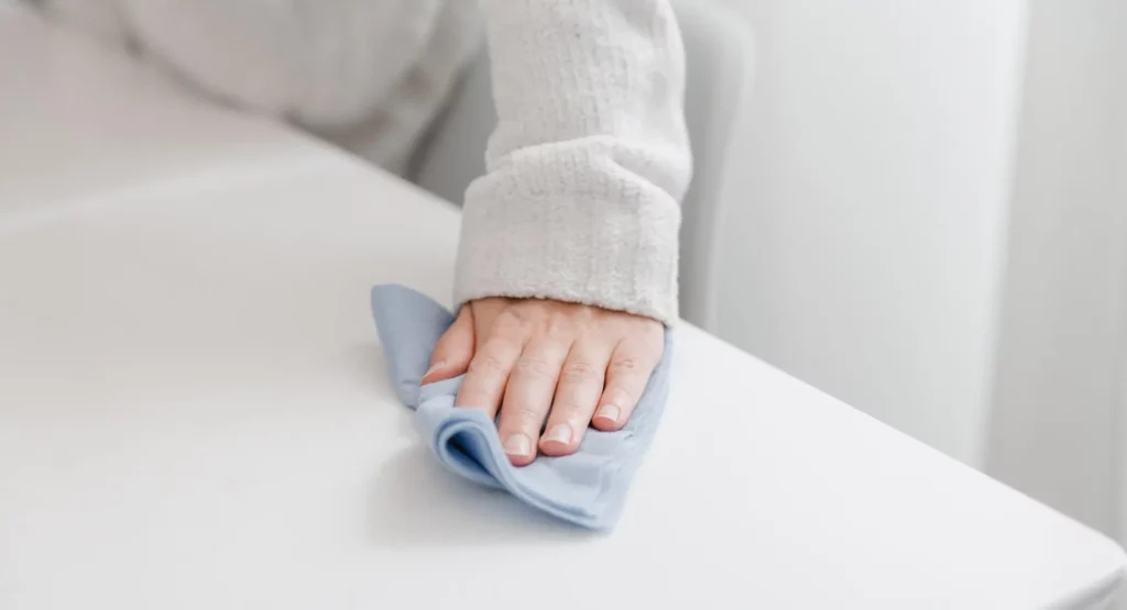 Ein Tisch wird mit einem Tuch abgewischt, um der Clean Desk Policy zu entsprechen.