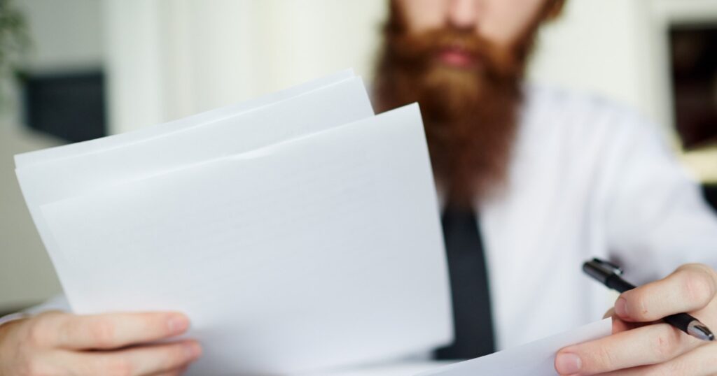 Kündigungsfrist prüfen – Unterlagen sorgfältig lesen Kündigungsfrist prüfen – Mann liest wichtige Unterlagen gründlich durch