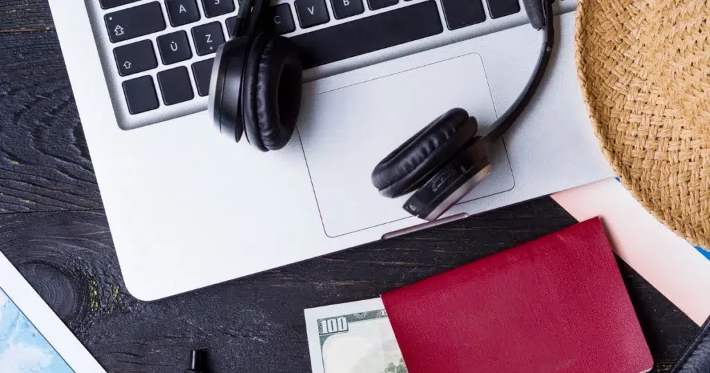 Urlaubsentgelt und Reisevorbereitung mit Laptop, Kopfhörern und Reisepass