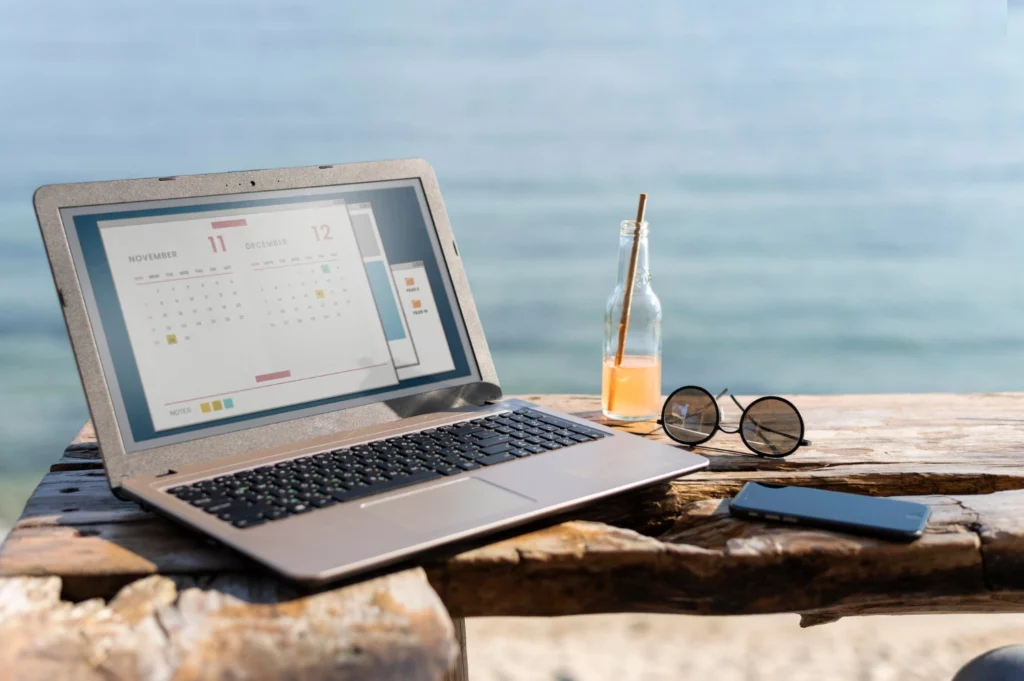 Urlaubsentgelt berechnen: Laptop mit Kalender am Strand