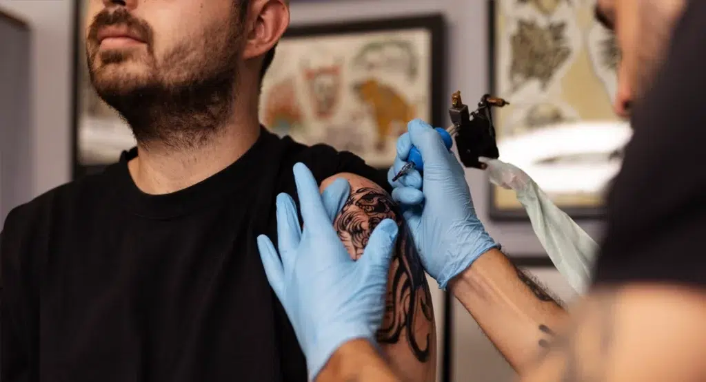 Mann beim Tättowierer