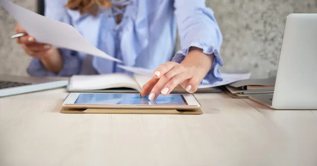 Arbeitsbescheinigung: elektronische Übermittlung an die Agentur für Arbeit Person bearbeitet digitale Unterlagen zur elektronischen Arbeitsbescheinigung am Tablet