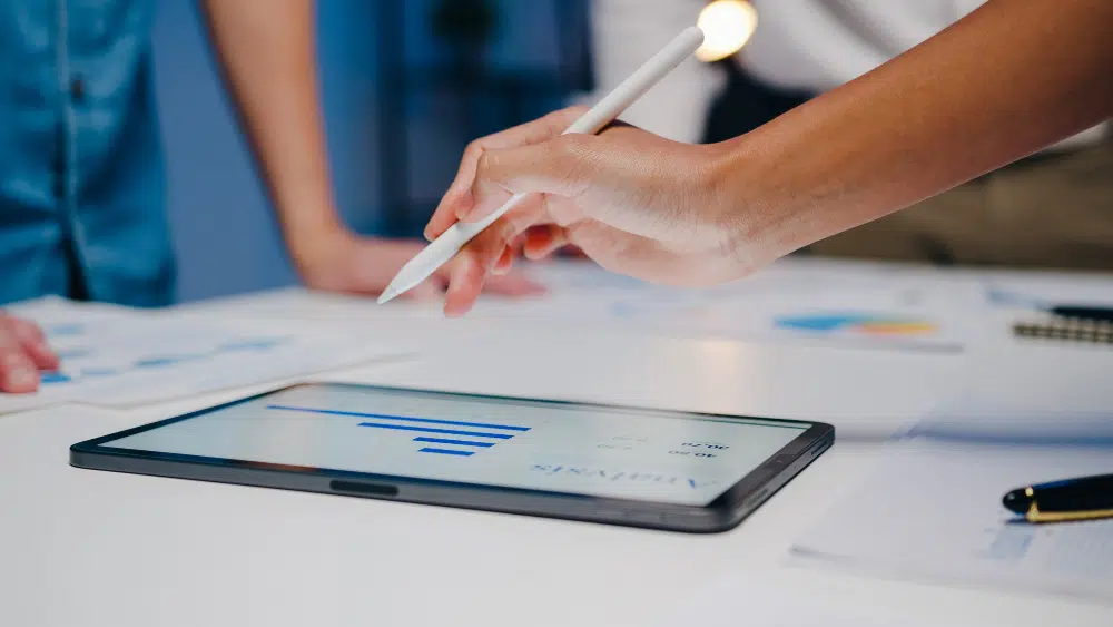 Digitale Personalakte: Sage HR im Vergleich HR-Team analysiert die Funktionen von verschiedenen Anbietern zu digitalen Personalakten auf einem Tablet
