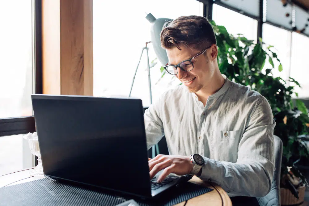 Mitarbeiter verwaltet sein Arbeitszeitkonto im Rahmen von Gleitzeit am Laptop