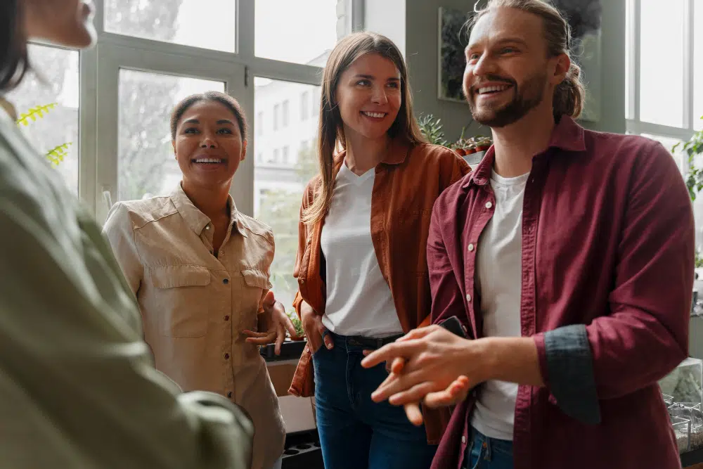 Ziele der Personalentwicklung: Motivation und Mitarbeiterbindung stärken Personalentwicklung im Team: Mitarbeitende im lockeren Gespräch als Symbol für Motivation und Mitarbeiterbindung bei der Arbeit